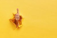 A "thumbs up" bursting through a yellow background