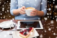 Woman with coffee at laptop with snow falling