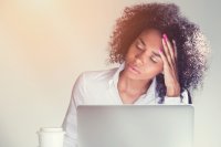 Stressed young female professional at laptop