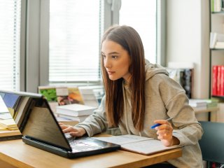 Female student studying laptop screen intently