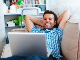 smiling man looking at his laptop