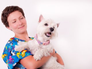 Vet assistant with cute dog in her arms